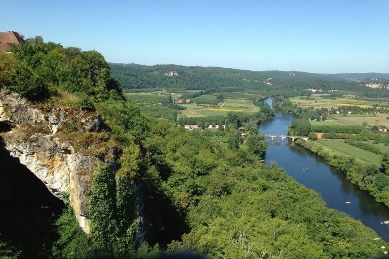Vue panoramique de la vallée verdoyante et rivière.
