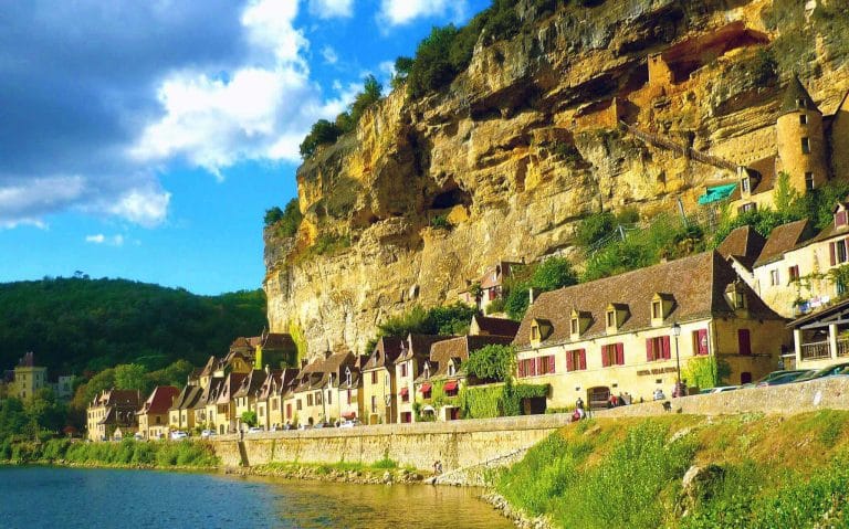 Maisons charmantes au bord d'une falaise ensoleillée.