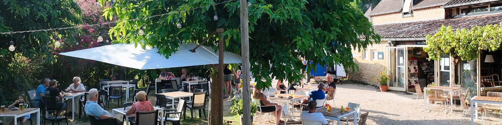 Terrasse de café ombragée avec des clients.